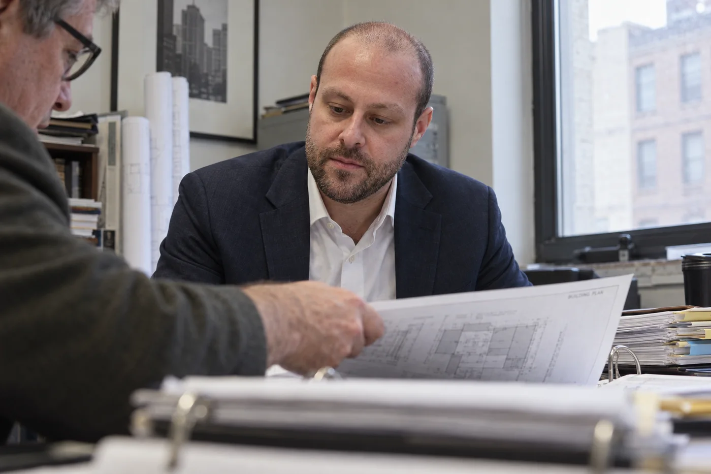 Joshua Butnick reviewing building records and registration filings with a property investor